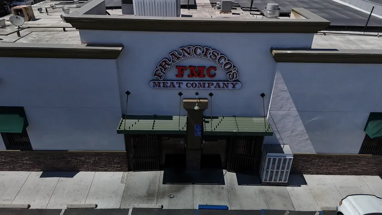 Elevated drone view of Francisco's Meat Company building with solar panels on flat roof