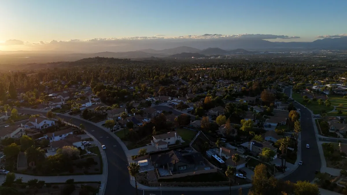Aerial view of Riverside, CA neighborhood with solar-equipped homes at sunset