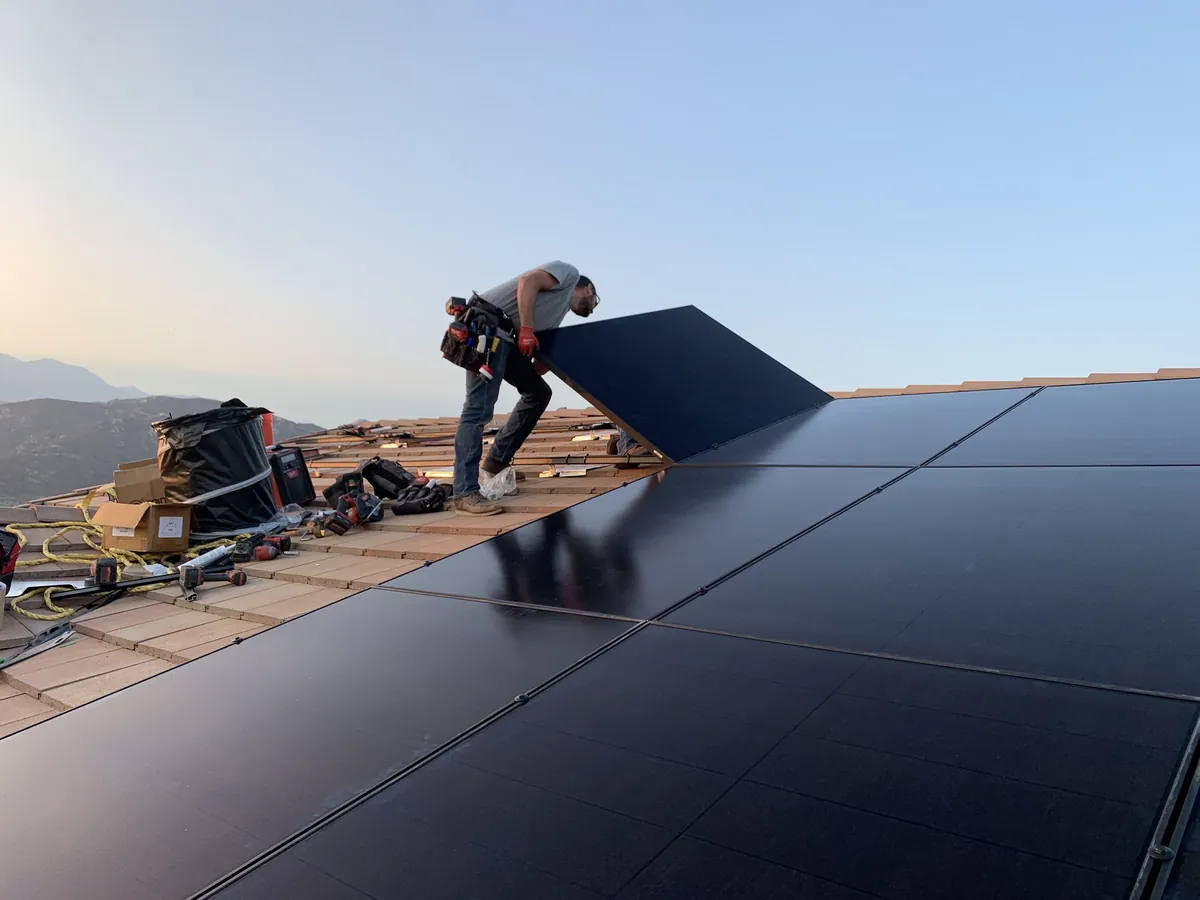 SolarCCS crew setting panels at golden hour on a Woodcrest rooftop